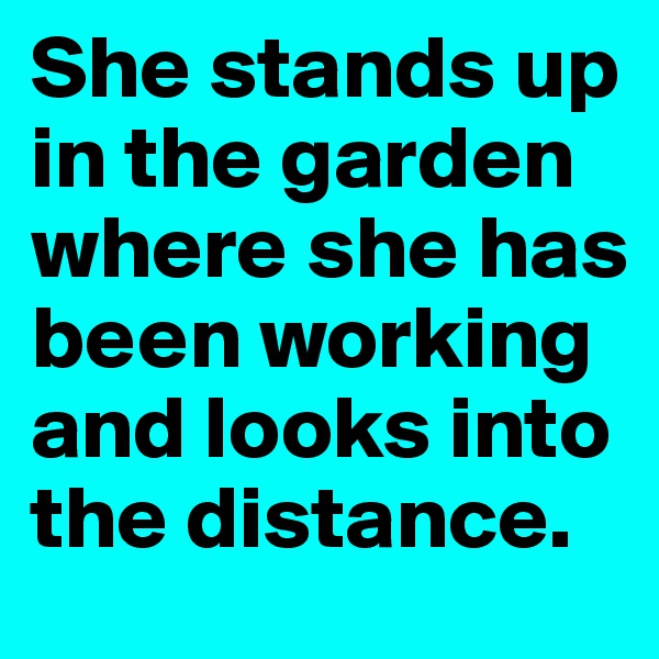 She stands up in the garden where she has been working and looks into the distance.
